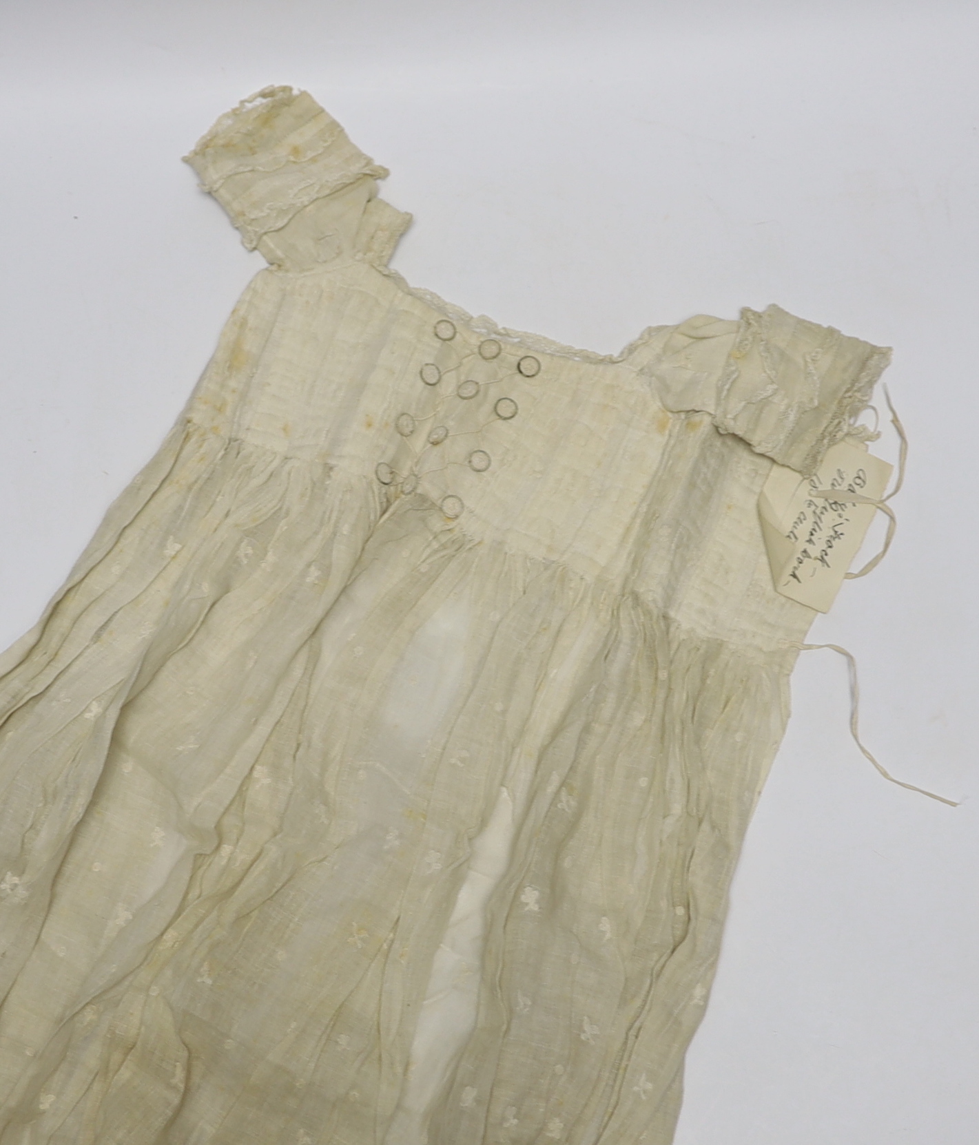 An early 18th century Hollie point insertion baby’s linen vest, three baby bonnets with Hollie point insertions and an early 18th century pair of Flemish bobbin lace lappets, a partly finished needlepoint length of lace,